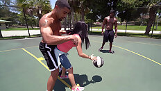 Michelle Martinez playing basketball with three black muscle dudes